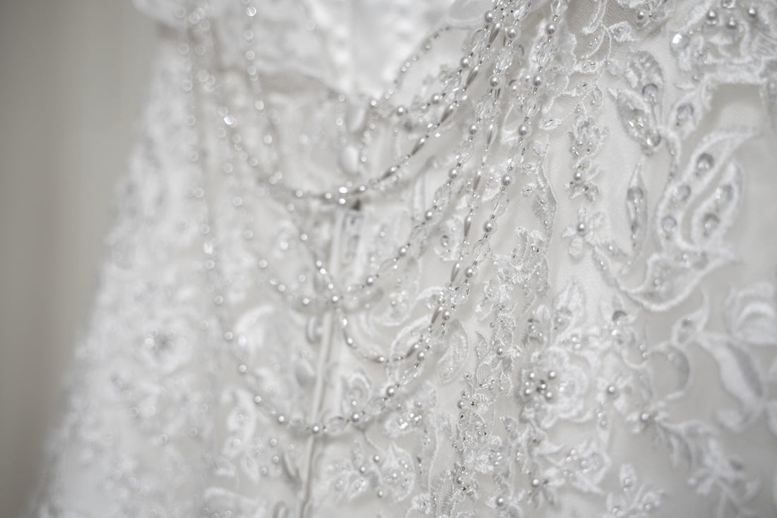 a close up of a wedding dress with beads on it