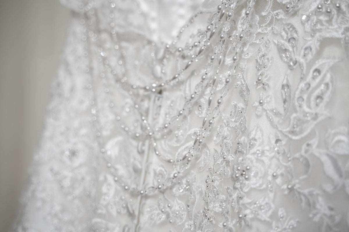 a close up of a wedding dress with beads on it