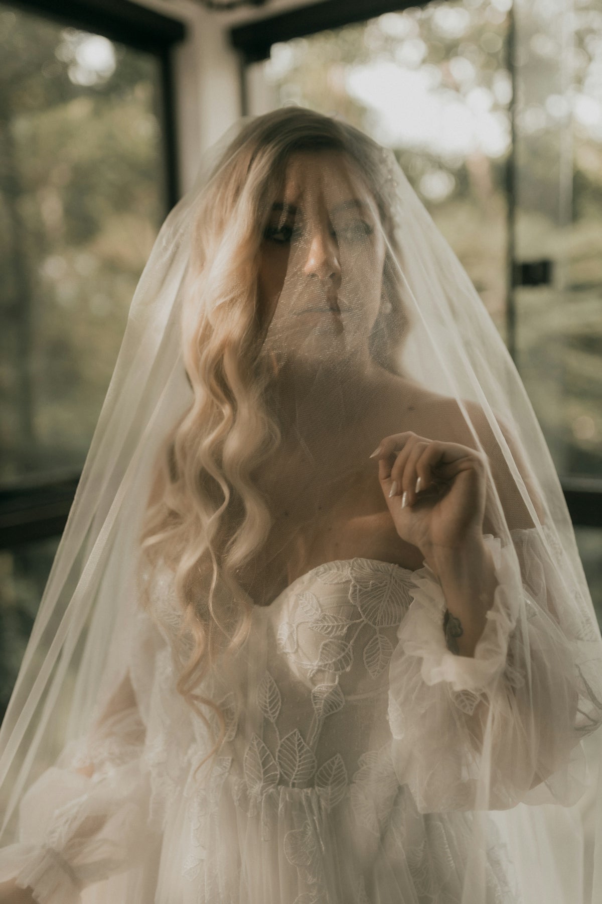 A bride poses behind her delicate veil.